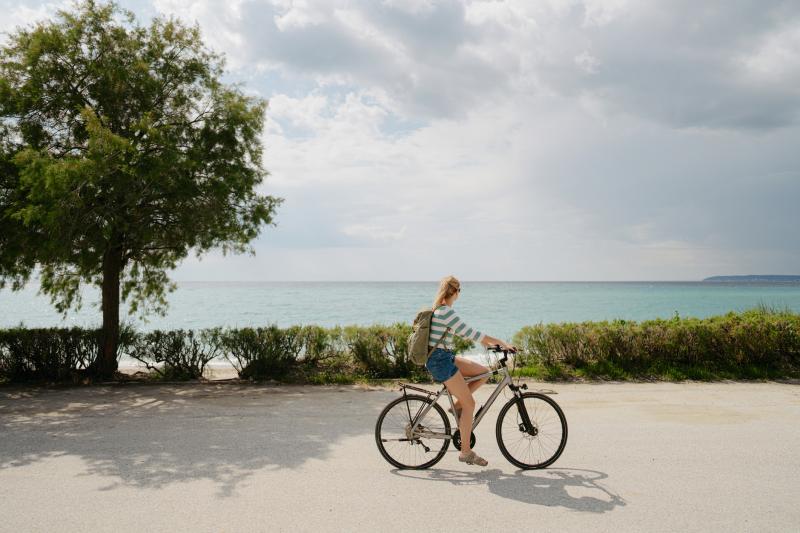 woman biking along the beach